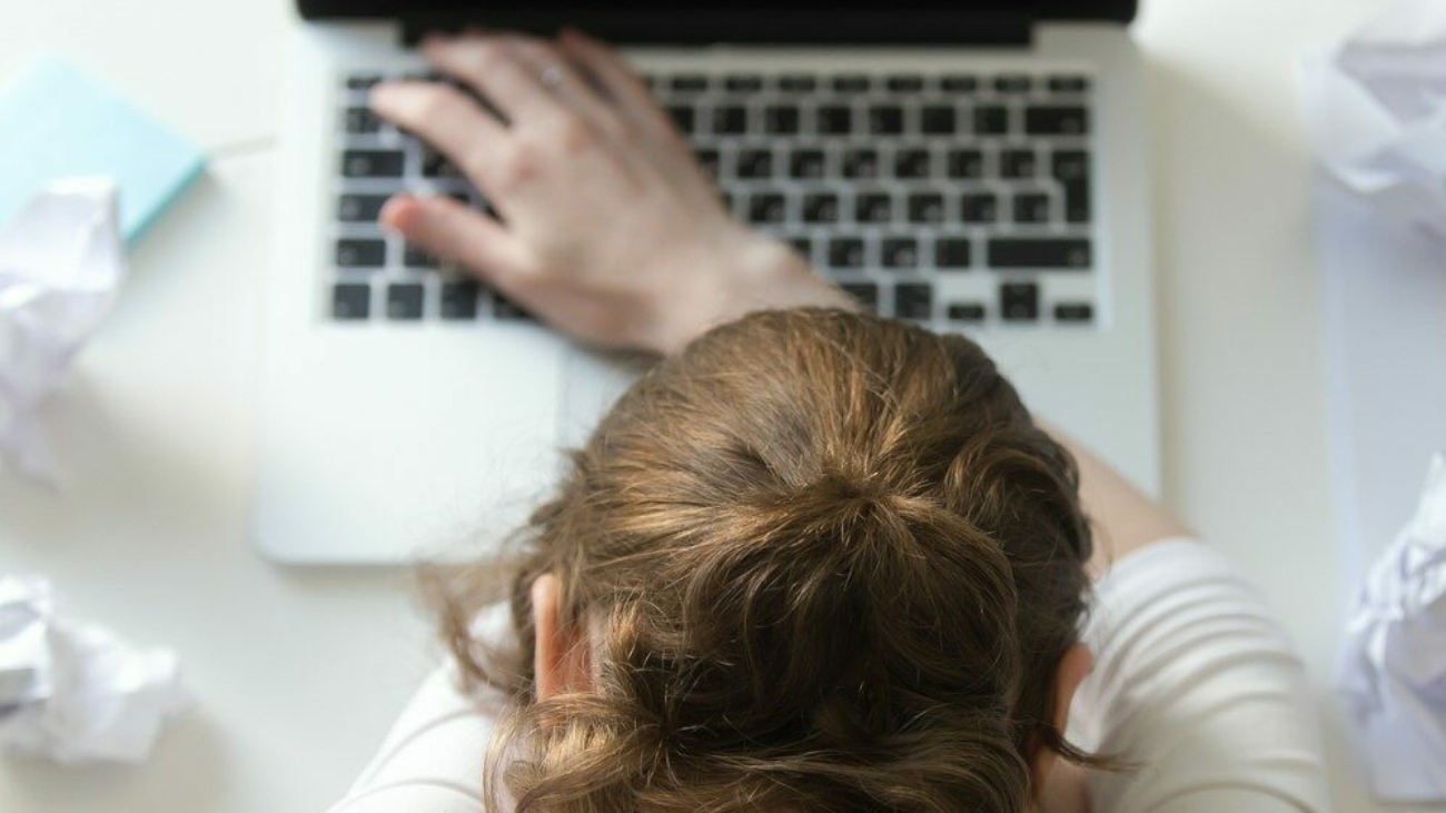 vista dall'alto di una donna distesa alla scrivania vicino al computer portatile